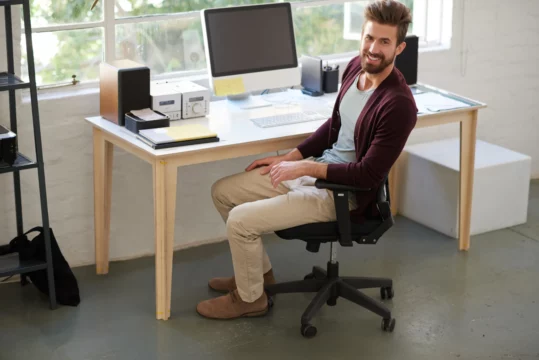 une personne qui travaille avec une chaise de bureau ergonomique