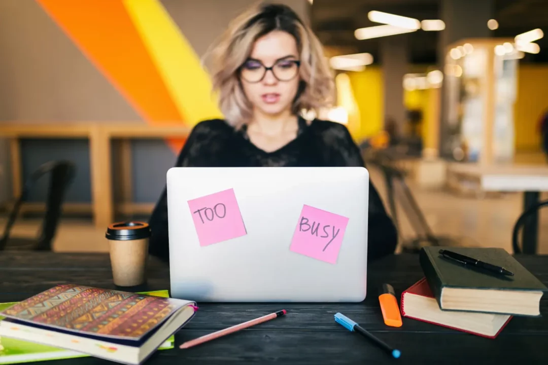 Une femme qui travail sur un ordinateur et qui est débordée