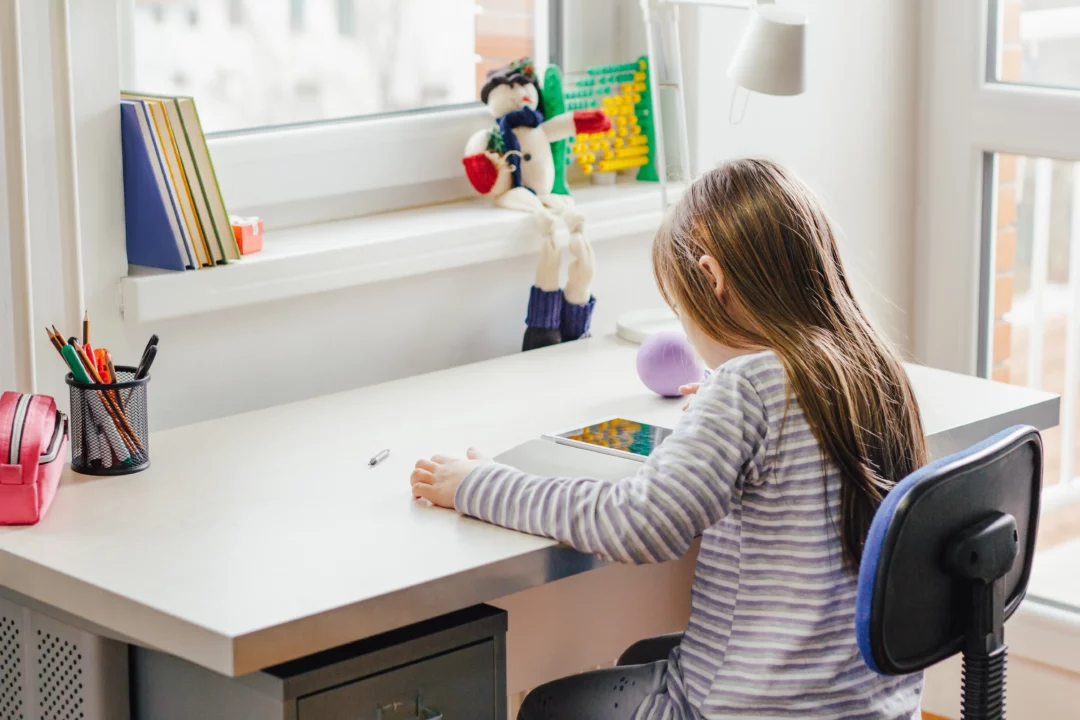 petite fille qui étudie au bureau à l'aide d'une tablette