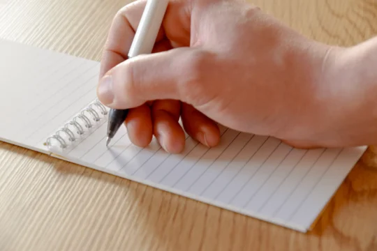 Utilisateur écrivant sur un carnet réutilisable A6 MOYU